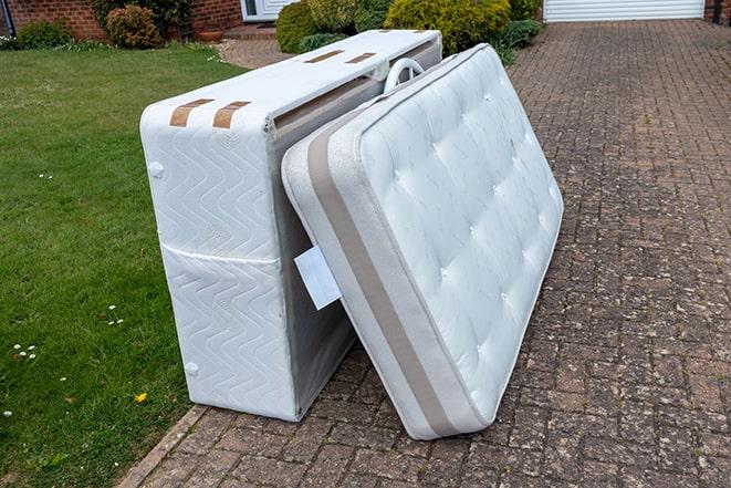 mattress being hauled away by a disposal team